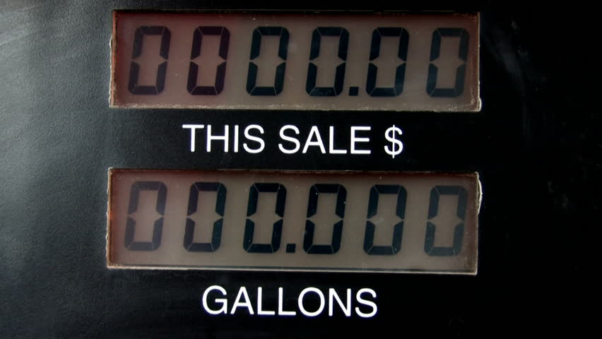 Gas pump showing dollars and gallons going up. Tops out at $75 when pump automatically turns off for credit card purchase. Time lapse fast motion.Gas company price gouging. High cost of driving.