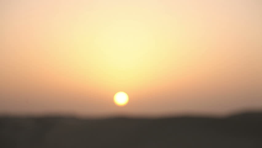 Hand and sand in the desert at sunset