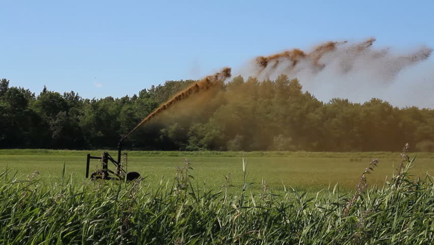 A machine is used to spread manure far across a farmer's field which will enrich the soil and help produce an abundance of crops/Manure Spreader/Manure Spreader