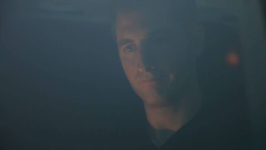 Looking through the windshield of a car at a tired driver