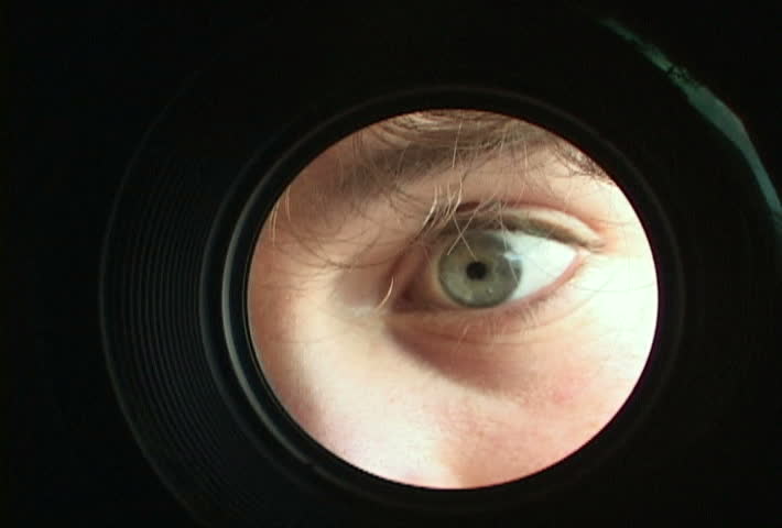 Camera man's eye looking through lens with reversed wide angle.