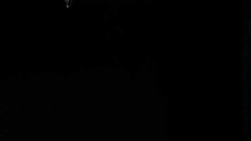Alarm clock in a super slow motion falling in water against a black background