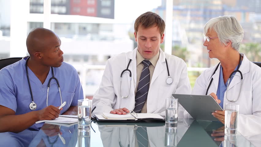 Medical team talking to each other in a bright office