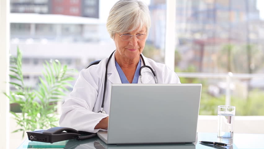Thoughtful practitioner working with a laptop in a bright office