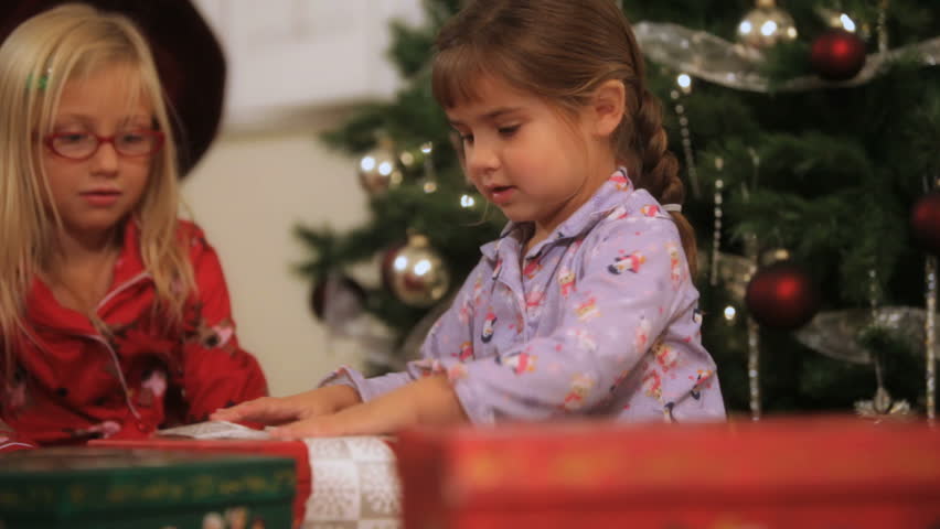 Two little girls opening gifts on Christmas day