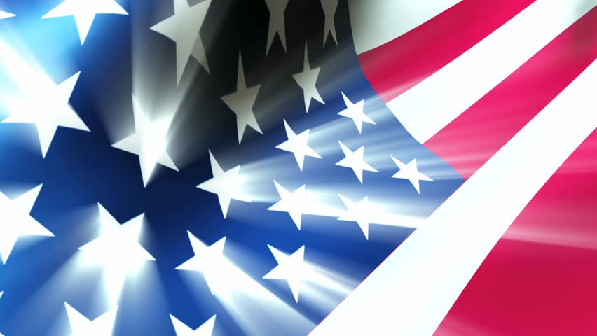 American Flag 0112 - The American flag waves in the breeze as light rays shoot from the stars.