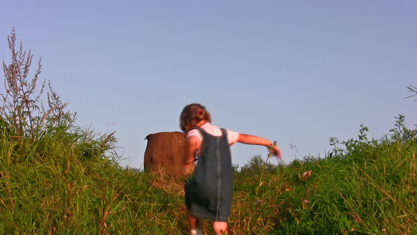 little girl climb on stump 