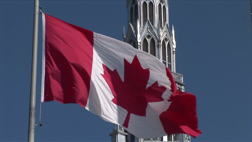 Close-up of Canadian Flag flapping in front of Parliament of Ottawa Canada