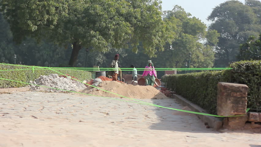 NEW DELHI, INDIA - JANUARY 16: A work crew builds a road on January 16, 2011 in New Delhi, India. People use mainly physical labour without heavy machinery for roadworks in India. 
