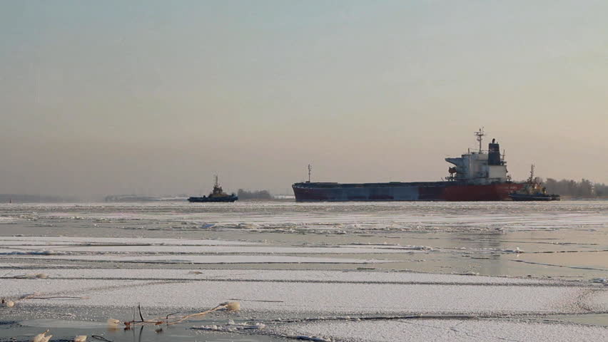Tug boats moving through Riga port during Winter, in Riga, Latvia.