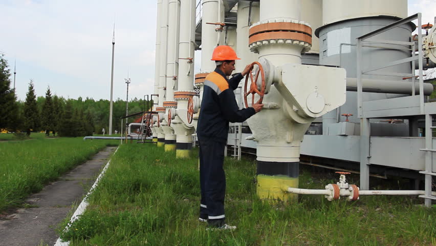 young engineer in orange helmet open valve on gas cleaning installation