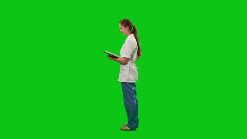 Young nurse moves around with a report. Green screen.