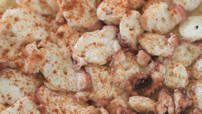 dressing tapa of cooked octopus slices with oil, top view