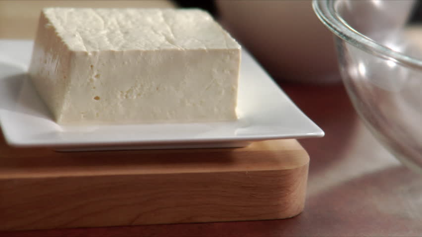 Close-up of chef slicing fresh tofu.