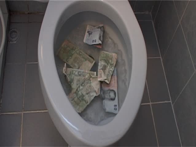 money being flushed down toilet