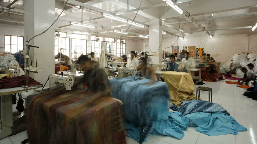 RASJASTHAN, INDIA - CIRCA MAY 2011: Factory workers using sewing machines in a garment factory