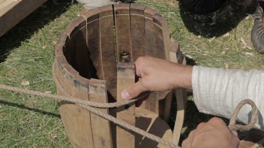 Two workers are making a barrel in a traditional style.
