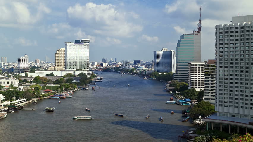 BANGKOK, THAILAND - CIRCA MAY 2011: Nautical Vessels along the Chao Phraya River passing Bangkoks Skyscrapers and Temples.