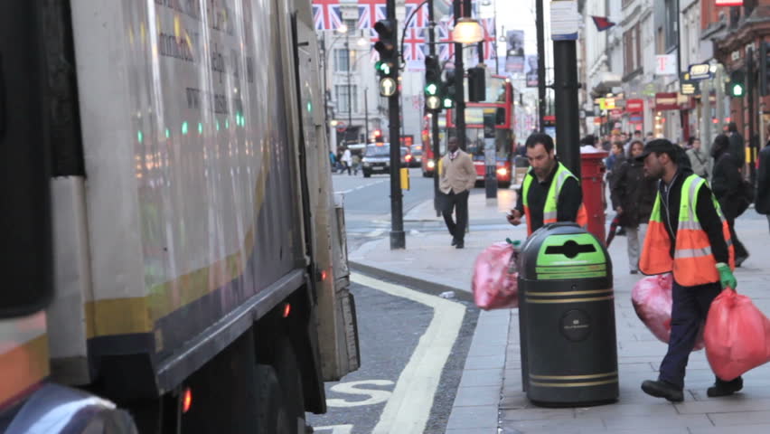 LONDON - MAY 14: Two unidentified bin men collect rubbish late in the evening on May 14, 2012 in London. The London Mayor, Boris Johnson, is considering plans to convert London's rubbish into energy.