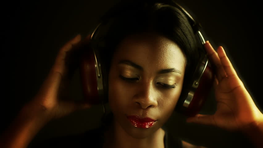 head shot close up sexy young woman posing and listening to music on headphones