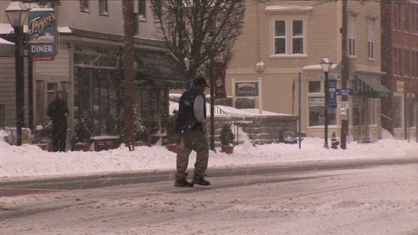 NEW ENGLAND - CIRCA JANUARY 2006: Pedestrian crosses snowy street