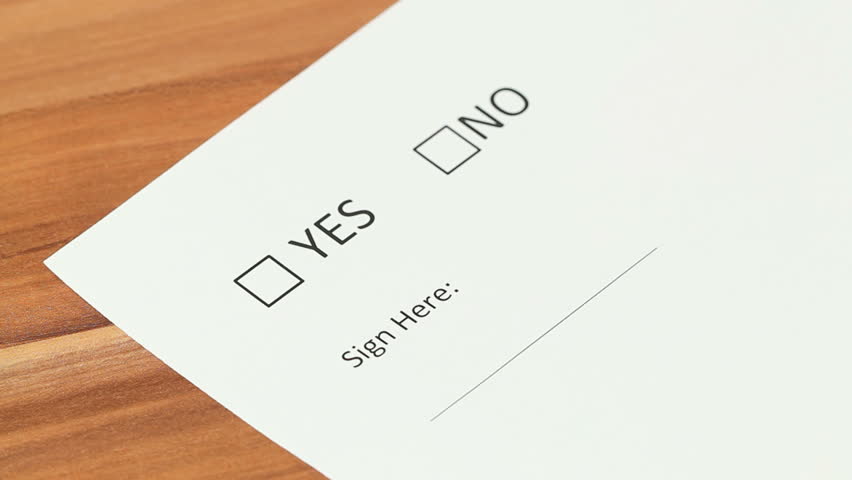 Woman deciding between yes and no checkbox, choosing yes and putting her signature using a fountain pen.