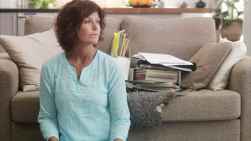 Mature woman sitting on ground doing paperwork