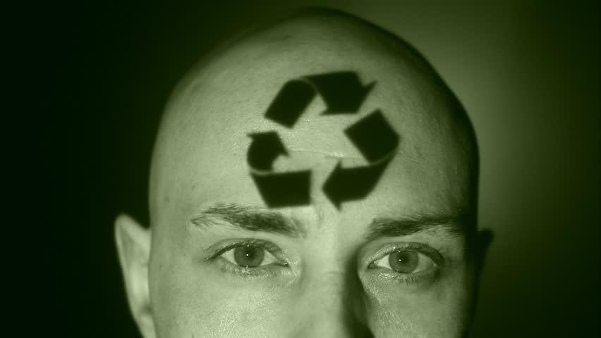 A man with recycling symbol projected on his face.