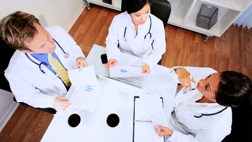 Overhead view meeting multi ethnic medical team in hospital boardroom