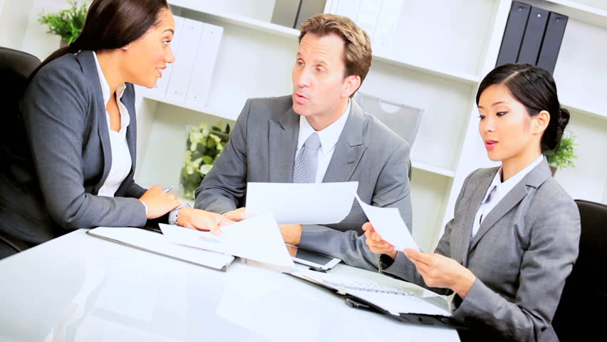 Three multi ethnic business colleagues meeting modern office