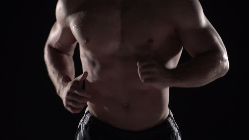 Muscular man running towards camera, torso shot center