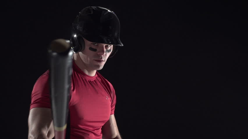 Baseball player swinging the bat, black background