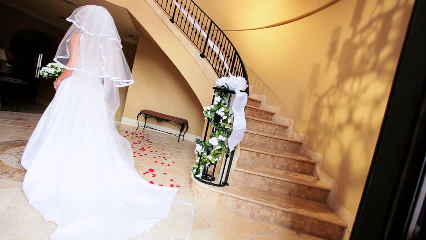 Beautiful blonde girl wedding dress and veil descending marble staircase