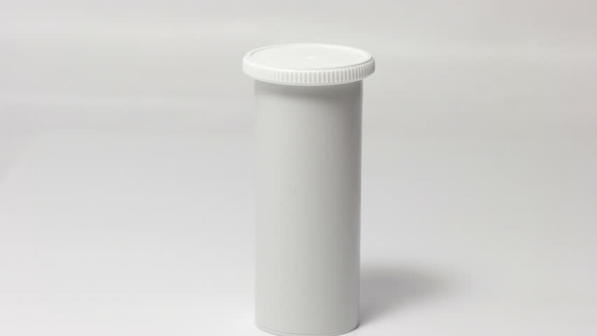 Hand takes a white vial