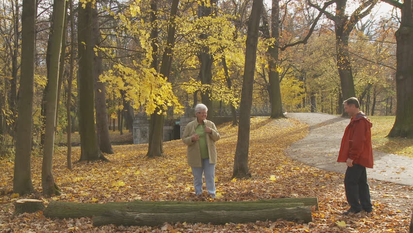 pensioner balancing on tree trunk in park