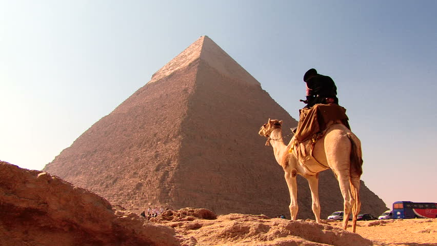 CAIRO, EGYPT - December 2008: Tourists seated at Giza complex on a sunny day with pyramids