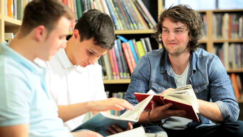 Male multi ethnic university friends working together degree in modern library