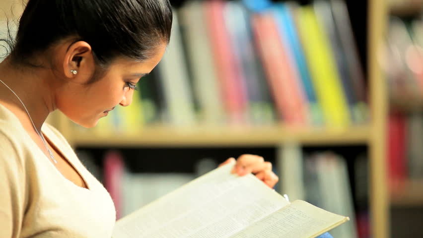 Indian female student learning university degree in campus library