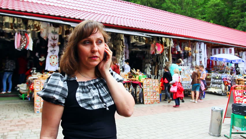 nice woman speaks by cell phone on Souvenir Market Yaremche, Ukraine