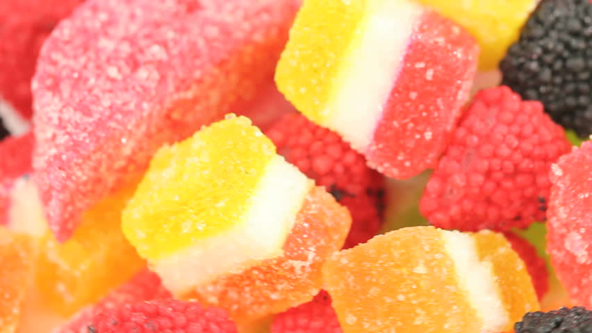 Colorful Jelly Cubes Background - Jelly cubes and berry jelly candy passing by in a loopable video, shot close up, vibrant color background