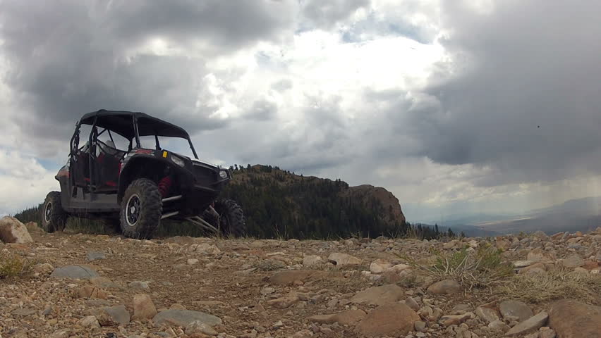 Silhouette man on top of mountain sport four wheel drive vehicle. Man explores the outdoor in the high Rocky Mountain Wasatch range. Sport utility vehicle used for recreation, transportation and fun.