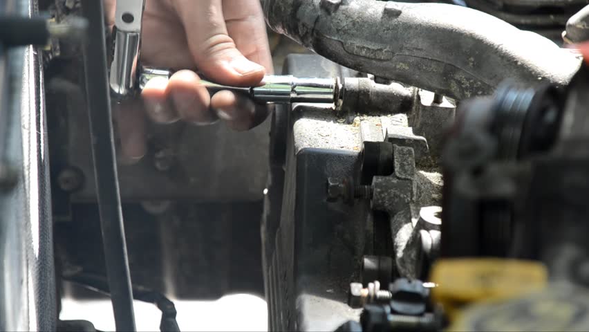 Mechanic unbolting the timing belt cover