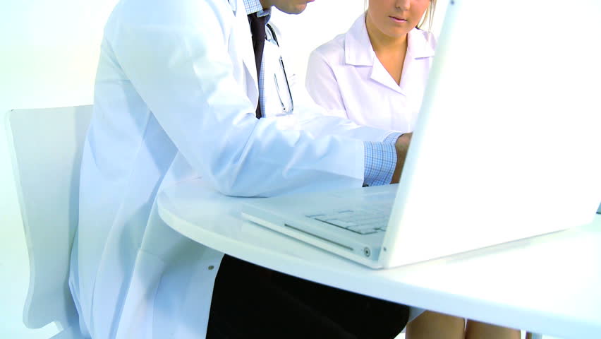 Young doctor & nurse examine patient records