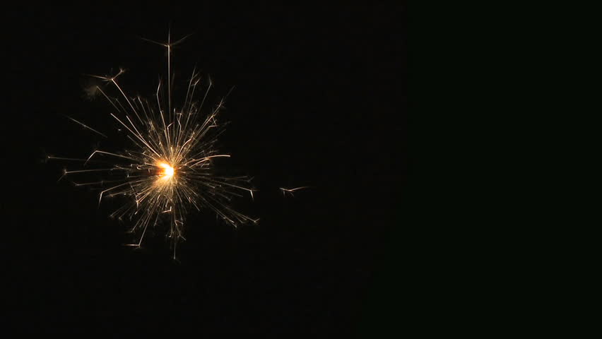 Sparkler. A bright fizzing sparkler on crushed black background. HD 25p