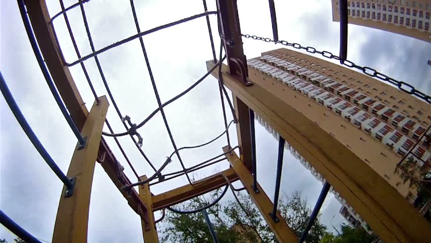 Girl hang on sports rings at playground in house yard