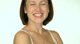 young woman standing with folded hands and laughing. camera moving up