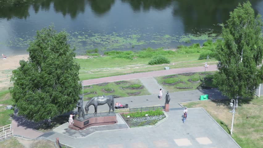 People walk near monument to Konstantin Batyushkov on quay in Vologda, Russia