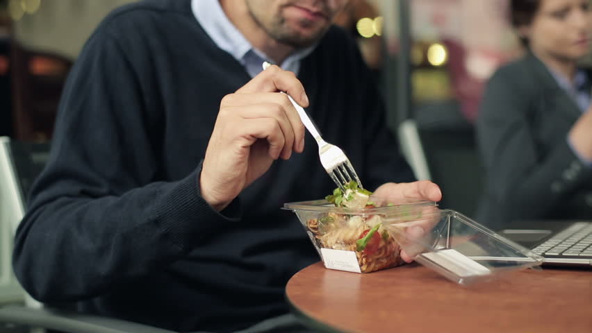 Businessman eating lunch in cafe, outdoor
