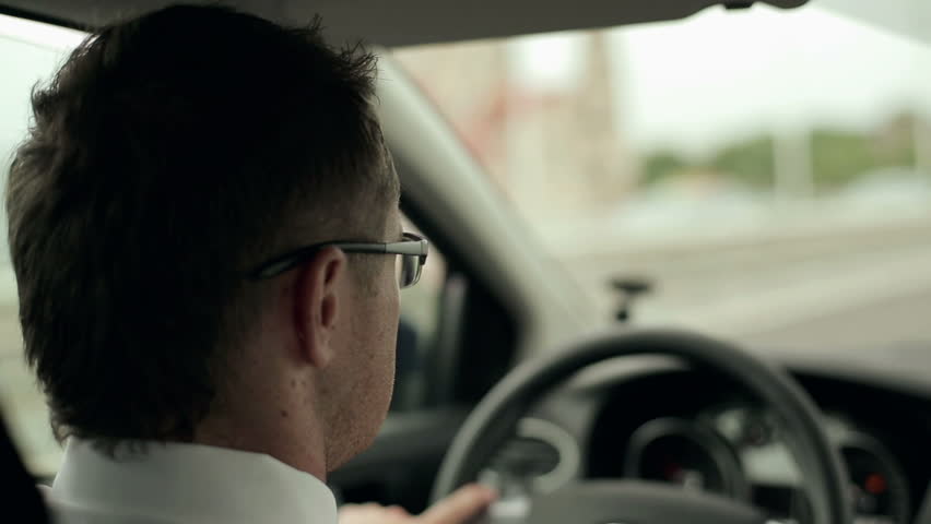 Young man driving a car, steadicam shot
