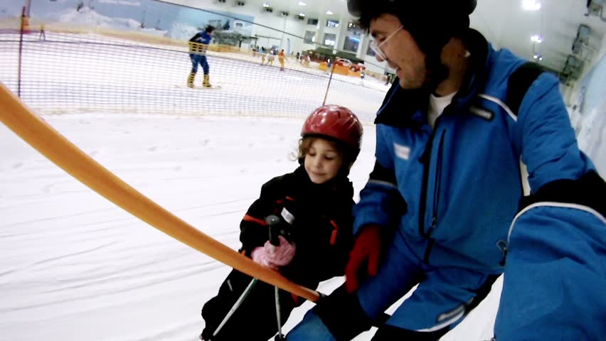  Father with daughter rise on skilift in yearround ski complex
